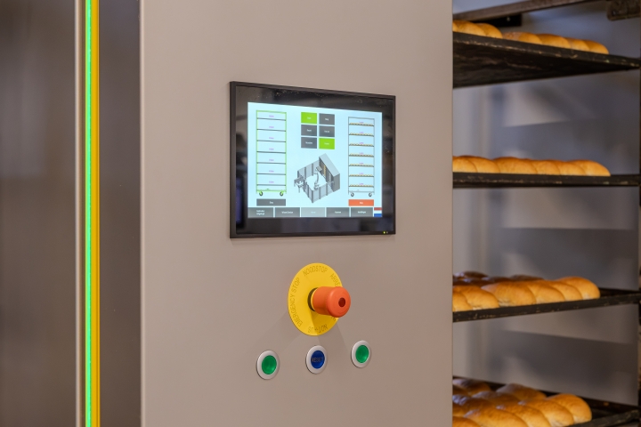 Geautomatiseerd ontladen van bakplaten met een industriële installatie.